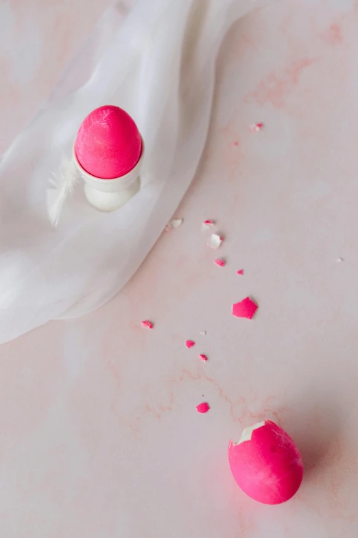 a couple of pink eggs sitting on top of a white cloth, inspired by Luma Rouge, trending on pexels, process art, lipstick, white neon, while marble, covered with pink marzipan