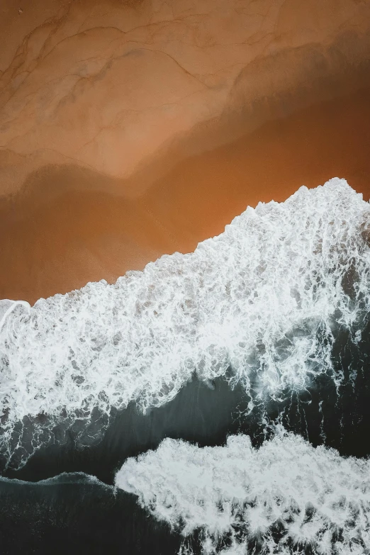 a large body of water next to a sandy beach, by Daniel Seghers, trending on unsplash, close-up from above, ocean spray, white and orange, unsplash photo contest winner