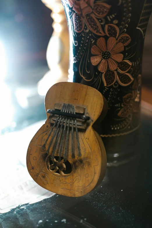 a guitar sitting on top of a table next to a vase, folk art, slide show, closeup - view, medium