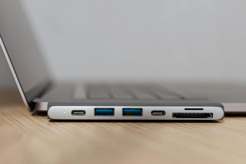 an open laptop computer sitting on top of a wooden table, by Carey Morris, pexels, usb ports, side view close up of a gaunt, multi-part, super high detail picture