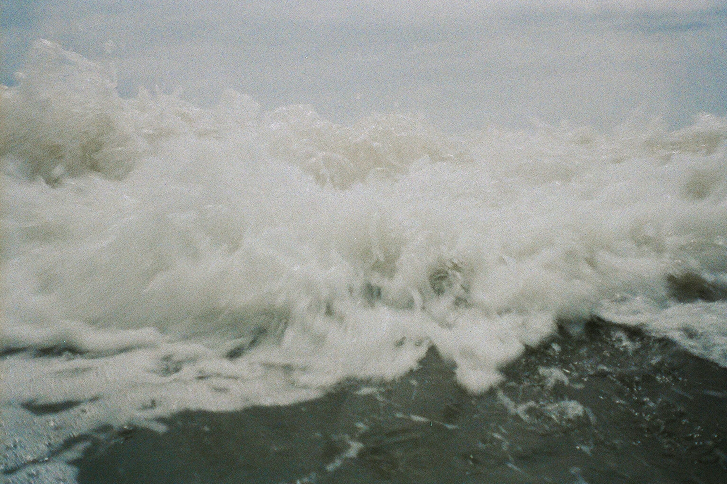 a man riding a wave on top of a surfboard, an album cover, unsplash, hurufiyya, experimental film, sea foam, ignant, boards of canada