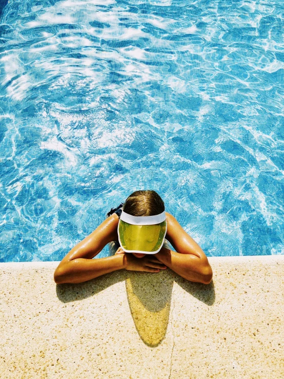 a woman sitting at the edge of a swimming pool, an album cover, pexels contest winner, visor over face, yellow helmet, hydration, instagram picture