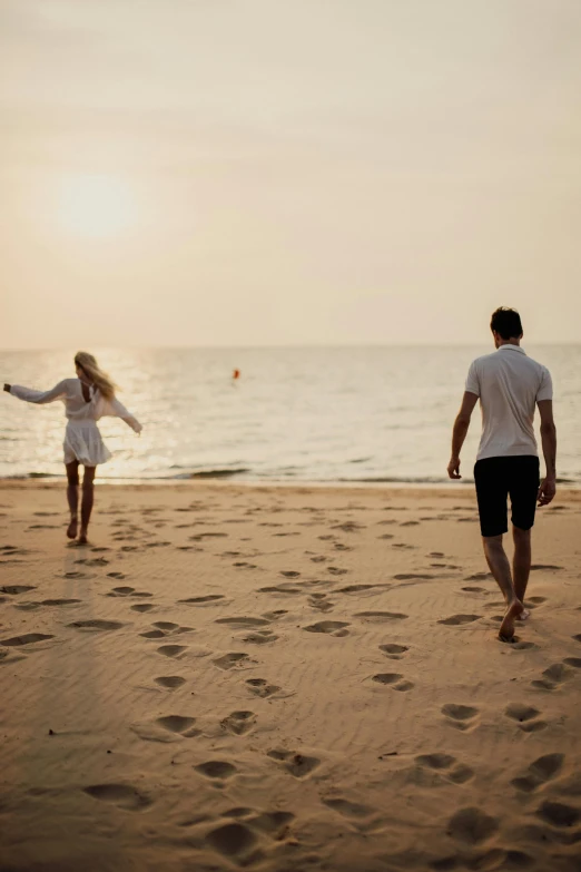 a man and a woman walking on a beach, pexels contest winner, soft shade, people running away, 12k, single