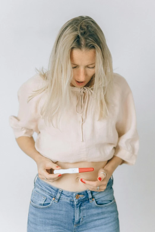 a woman holding a toothbrush in her stomach, by Nicolette Macnamara, happening, jovana rikalo, on a white table, diagnostics, sydney hanson