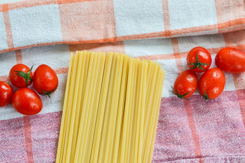 a pile of pasta sitting on top of a table next to tomatoes, a picture, tablecloth, thin straight lines, 🦩🪐🐞👩🏻🦳, promo image