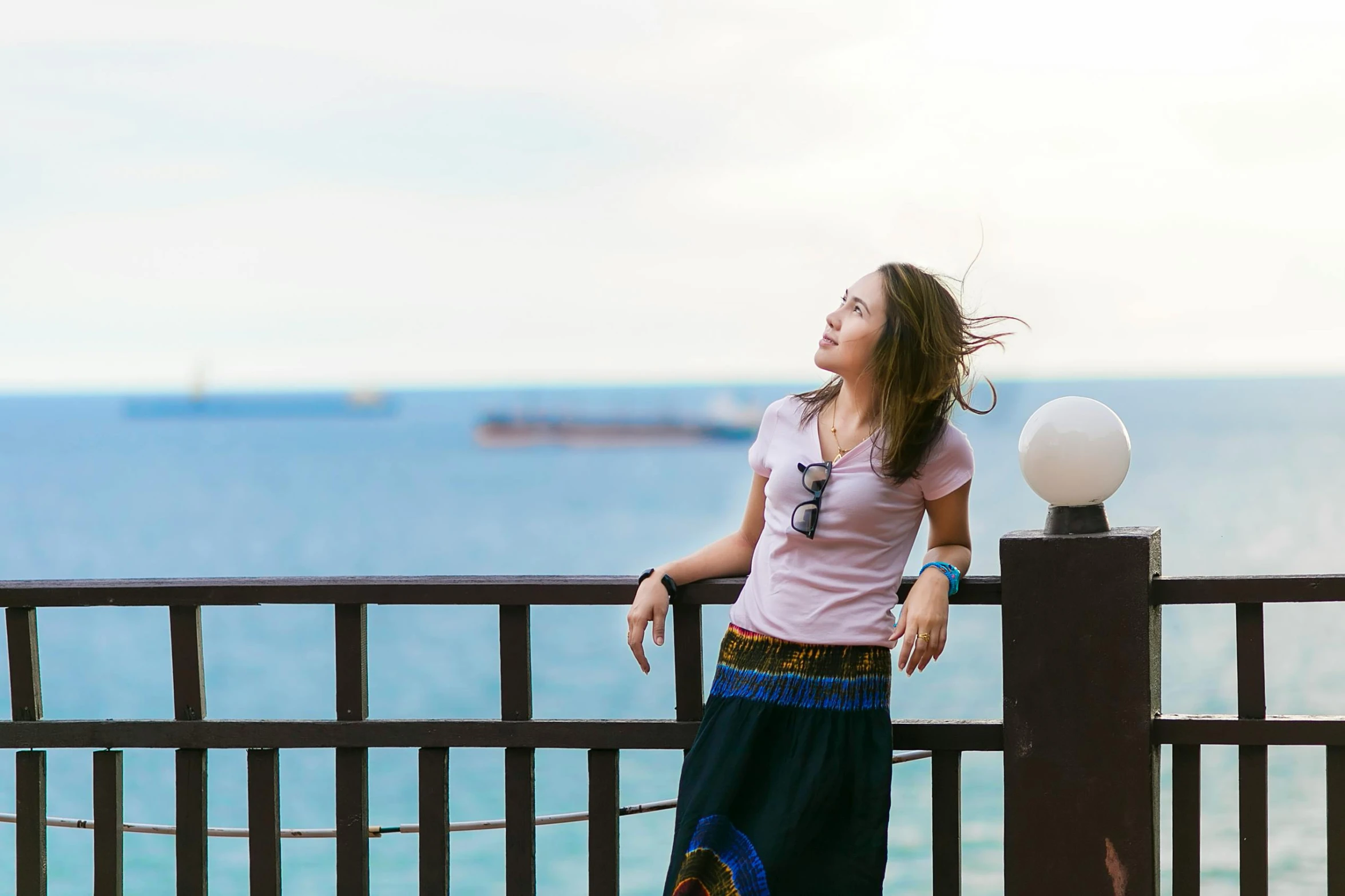 a woman standing on top of a pier next to the ocean, a portrait, pexels contest winner, balcony, relaxed expression, sofya emelenko, chinese woman