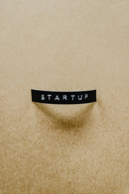 a sticker with the word start up on it, trending on unsplash, panel, waist high, product introduction photo, kubric stare