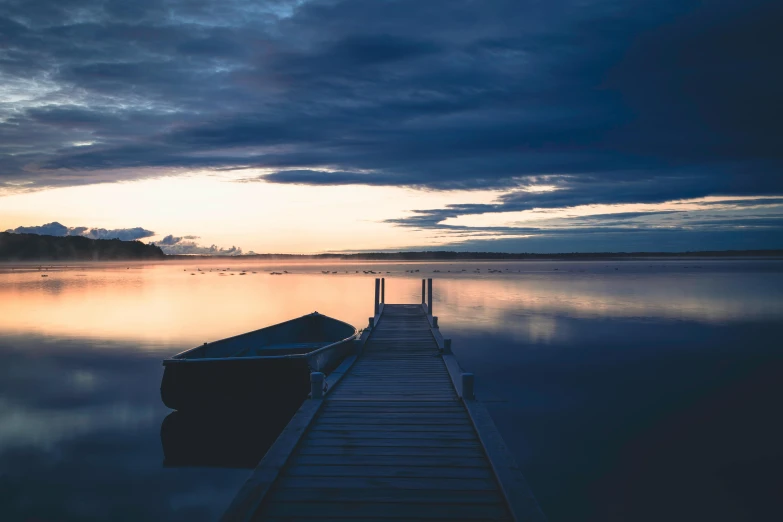 a boat sitting on top of a lake next to a dock, by Jesper Knudsen, pexels contest winner, calm evening, fine art print, lachlan bailey, instagram picture