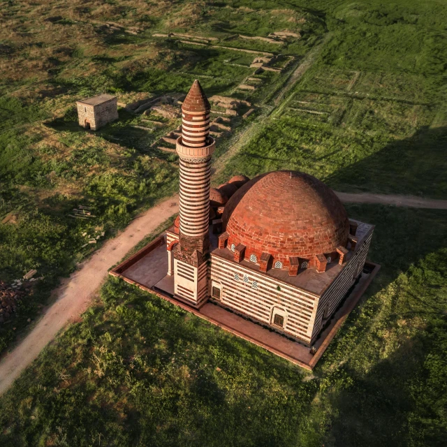 a large building sitting on top of a lush green field, by Daren Bader, hurufiyya, high - angle view, lead - covered spire, taken in the early 2020s, akiman