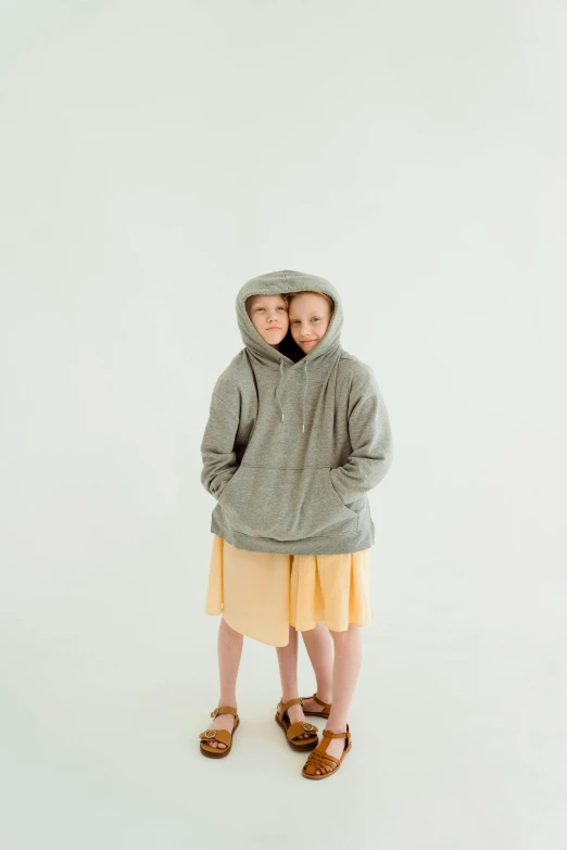 a couple of young girls standing next to each other, an album cover, by Maeda Masao, unsplash, gray hoodie, alec soth : : love, cute huge pockets, kids