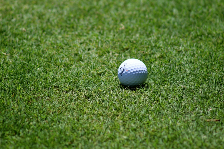 a golf ball sitting on top of a lush green field