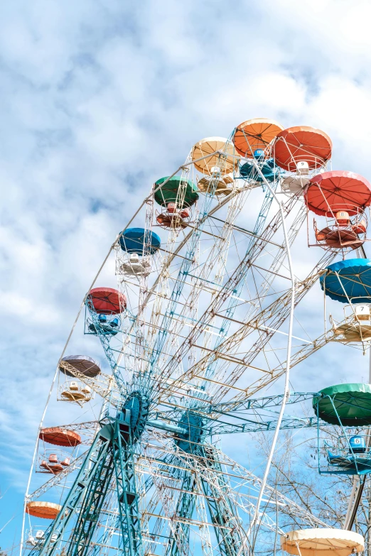 a ferris wheel with colorful umbrellas on a cloudy day, a portrait, pexels contest winner, light blue sky, square, 2022 photograph, brown