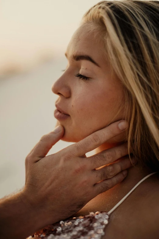 a woman standing on top of a beach next to a man, by Gavin Hamilton, trending on pexels, renaissance, hand on her chin, soft shadows on the face, on a young beautiful woman neck, skin details