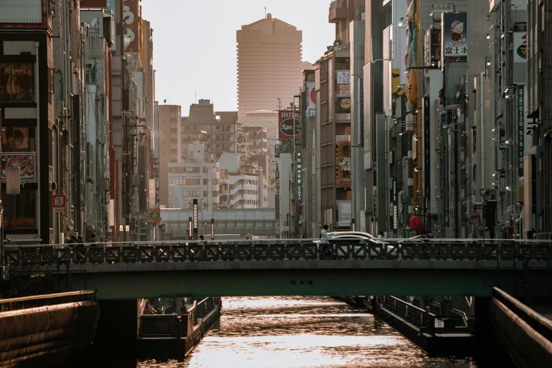 a river running through a city next to tall buildings, a picture, inspired by Kōno Michisei, pexels contest winner, footbridges between houses, 🚿🗝📝