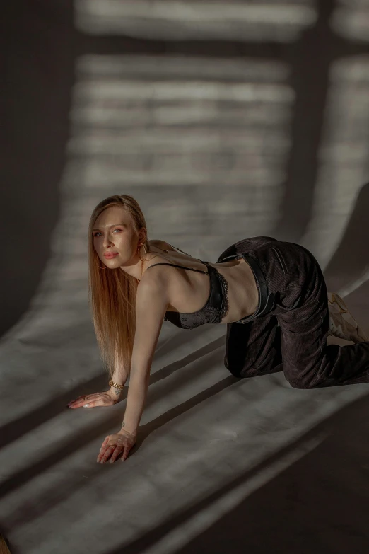 a woman laying on the ground in a dark room, unsplash, photorealism, doing a sassy pose, with backlight, portrait of kim petras, shadow play