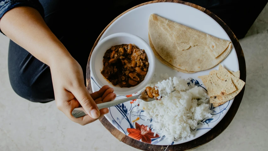 a close up of a person holding a plate of food, pexels contest winner, dau-al-set, sri lanka, background image, spoon placed, miranda meeks