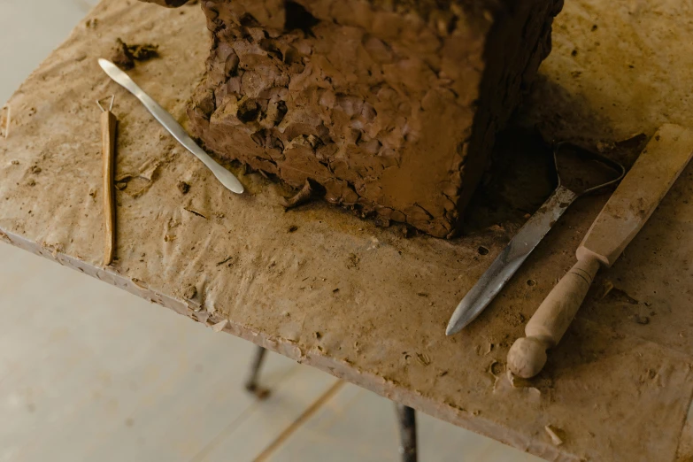 a piece of cake sitting on top of a table, inspired by Joseph Beuys, unsplash, clay texture, gardening, fully chocolate, rectangular