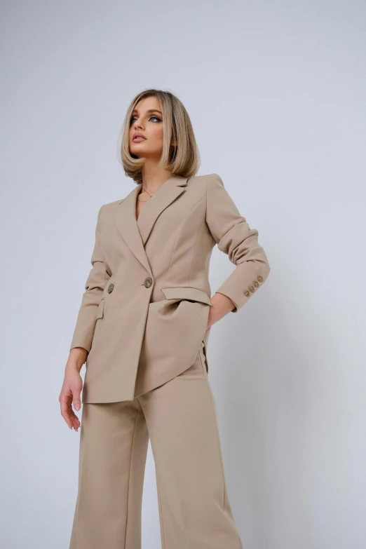 a woman in a tan suit standing with her hands on her hips, by Robbie Trevino, modelling, wearing a blazer, lena oxton, blonde crea