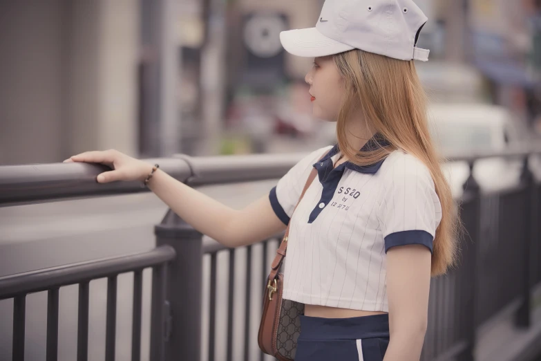 a beautiful young woman standing next to a metal fence, inspired by Cheng Jiasui, trending on pexels, realism, wearing polo shirt, white cap, trending at cgstation, wearing a cropped top