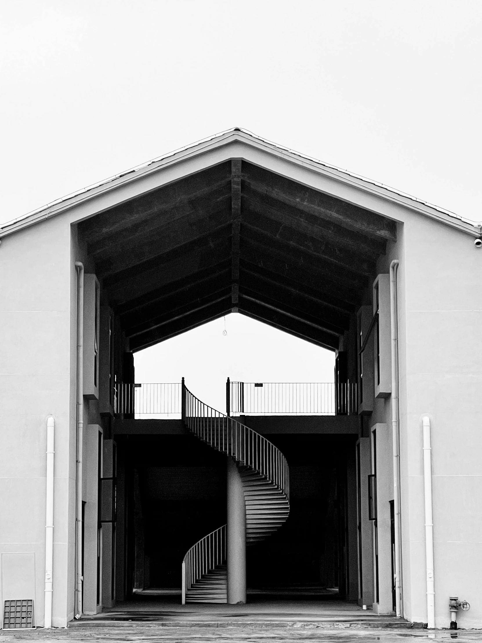 a black and white photo of a building with a spiral staircase, unsplash, in front of a garage, shot on iphone 6, minimalism, complex composition!!