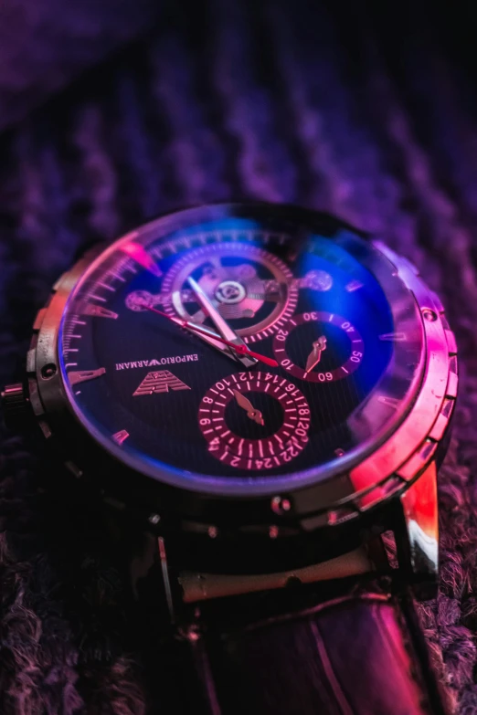 a close up of a watch on a cloth, a digital rendering, by Adam Marczyński, pexels contest winner, bright pink purple lights, red and blue black light, vintage look, avatar image