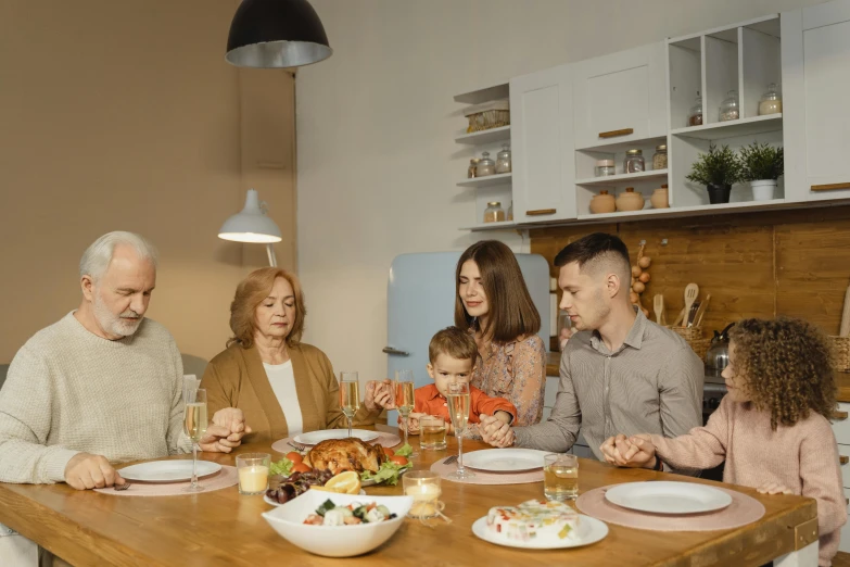 a group of people sitting around a wooden table, religion, at home, profile image, english