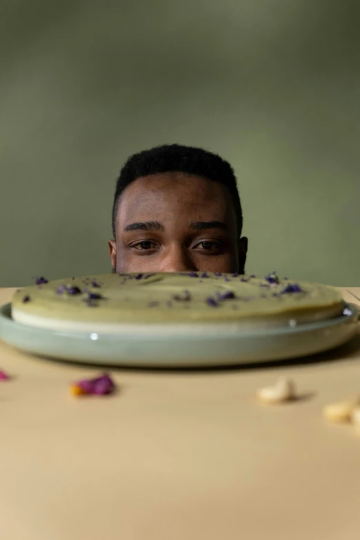 a man sitting at a table with a plate of food in front of him, an album cover, trending on unsplash, hyperrealism, face covered in dirt, mkbhd, flowers around, pie eyes