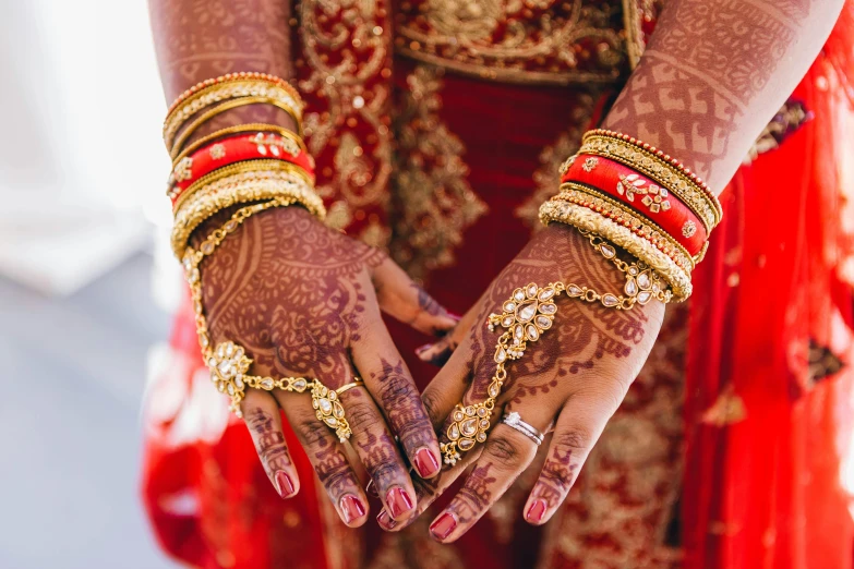 a close up of the hands of a bride, pexels, hurufiyya, red and gold, varying ethnicities, instagram post, brown