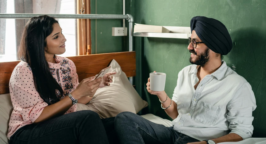 a man and a woman sitting on a bed, inspired by Manjit Bawa, trending on pexels, next to a cup, in chippendale sydney, talking, good friends