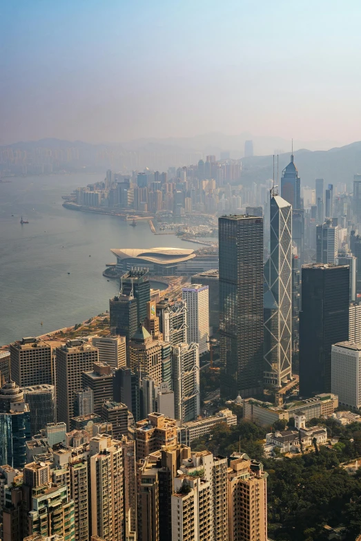 a view of a city from the top of a building, by Patrick Ching, pexels contest winner, hazy water, hong kong buildings, frank gehry, aerial photograph of skyscraper