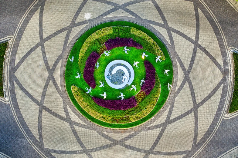 an aerial view of a circular flower garden, by Jan Rustem, doves flying into the portal, 2022 photograph, sundial, mother earth