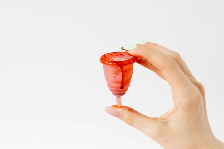 a close up of a person holding a bottle of liquid, by Nicolette Macnamara, plasticien, awkwardly holding red solo cup, made of lollypops, natural point rose', on a white background