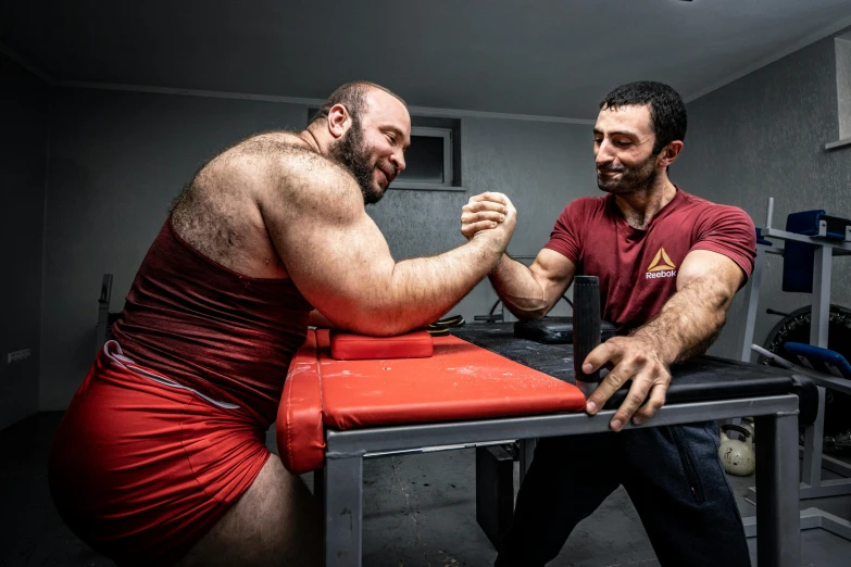 two men arm wrestling in a gym, a portrait, by Alexander Fedosav, pexels contest winner, real life photo of a syrian man, giant bear human hybrid, train with maroon, high quality photo