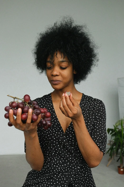 a woman holding a bunch of grapes in her hands, pexels contest winner, photo of a black woman, contemplating, partially cupping her hands, breakfast