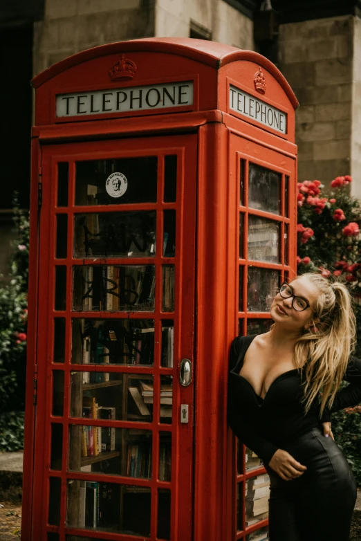 a woman leaning against a red telephone booth, a photo, pexels contest winner, she wears harry potter glasses, lush surroundings, square, aaaaaaaaaaaaaaaaaaaaaa