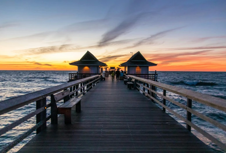 a pier leading into the ocean at sunset, by Niko Henrichon, pexels contest winner, renaissance, houses on stilts, gazebos, florida man, naples