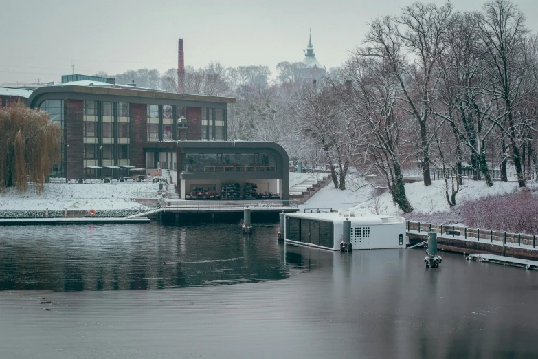 a body of water surrounded by snow covered trees, by Jaakko Mattila, pexels contest winner, modernism, brutalism buildings, moored, maroon, bored ape yacht club