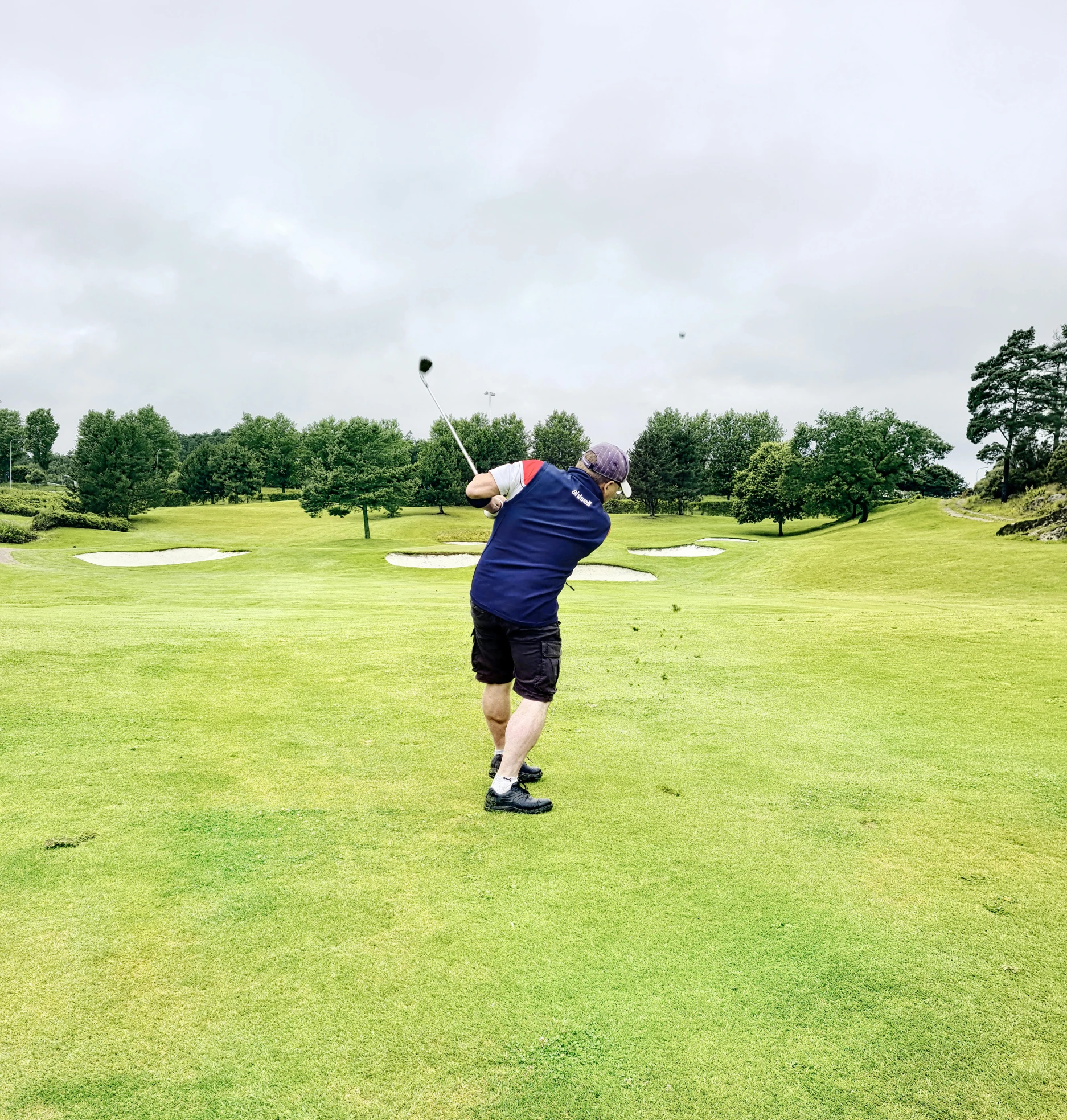 a man swinging a golf club at a golf course, unsplash, poor quality, avatar image, big overcast, lisa brawn