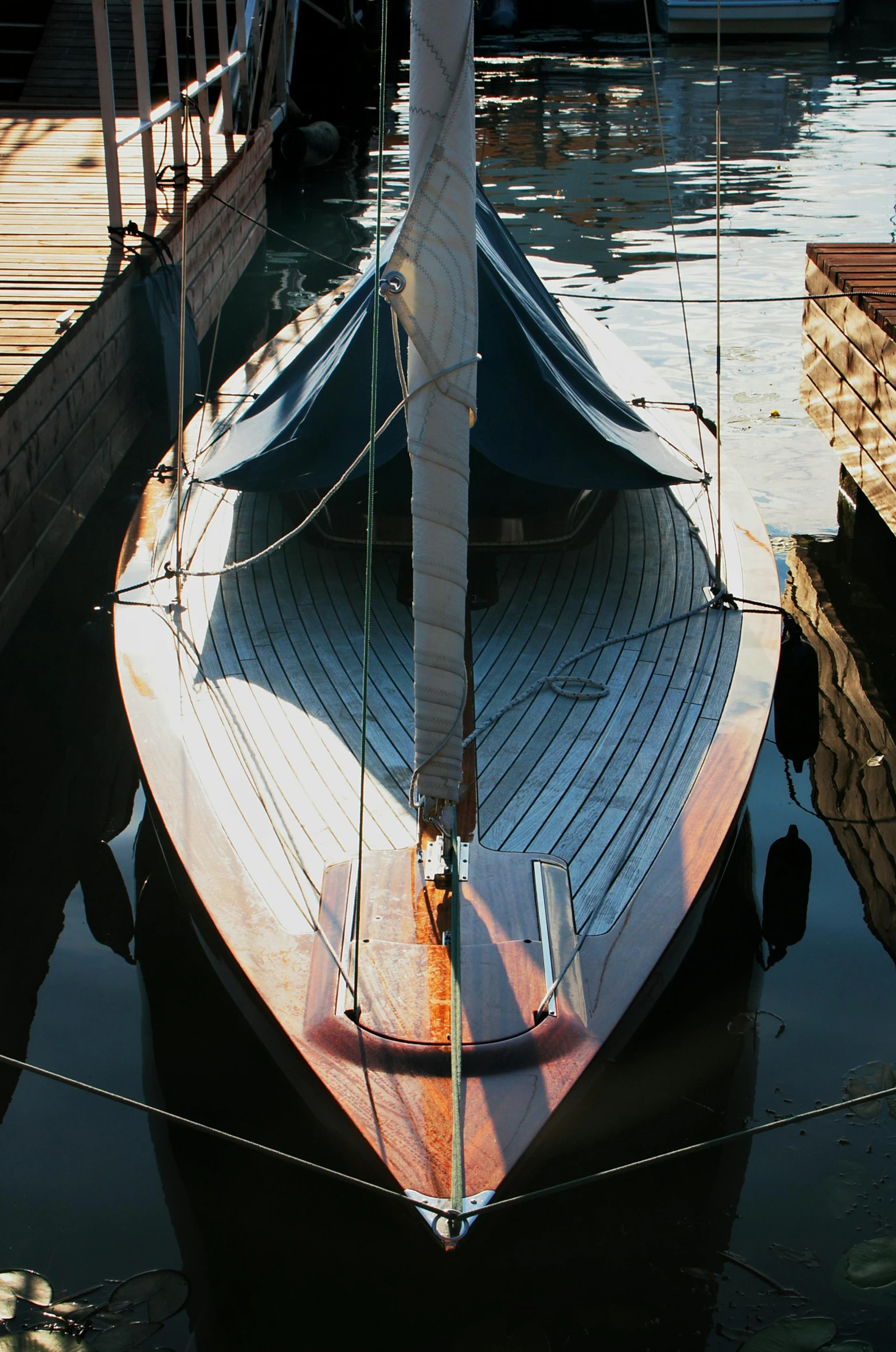 a boat that is sitting in the water, sitting on a wooden dock, looking down from above, on display, sail