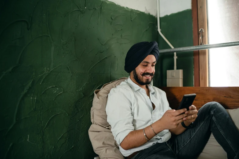 a man sitting on a bed looking at his cell phone, inspired by Manjit Bawa, trending on pexels, renaissance, sitting on a store shelf, playful smirk, sitting in a waiting room, avatar image