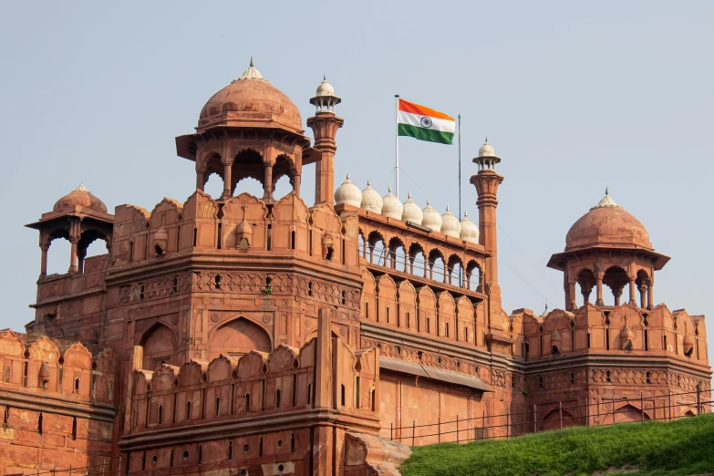 a large building with a flag on top of it, ancient india, fan favorite, city walls, maintenance photo