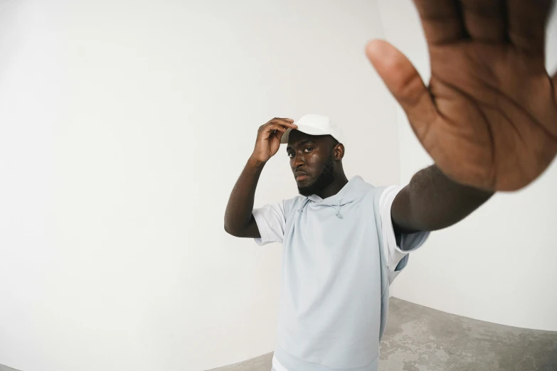 a man holding his hand up in the air, inspired by Paul Georges, pexels contest winner, pale blue outfit, sleek visor, virgil abloh, selfie shot straight on angle