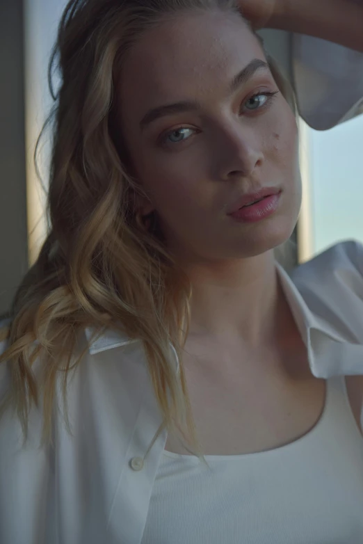 a woman sitting on top of a bed next to a window, unsplash, photorealism, margot robbie face, wearing a white button up shirt, soft light.4k, sydney sweeney