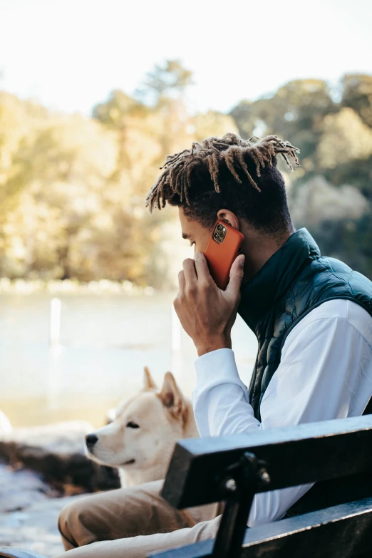 a man sitting on a park bench talking on a cell phone, trending on pexels, visual art, dog ears, portrait willow smith, on a lake, backlit ears