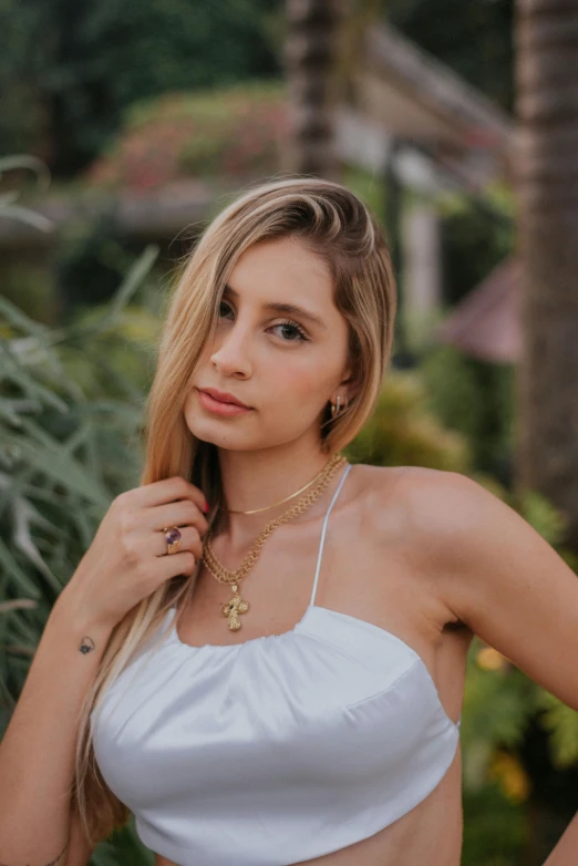 a woman in a white top posing for a picture, a portrait, by Robbie Trevino, trending on pexels, wearing gold jewellery, bali, square, julia sarda