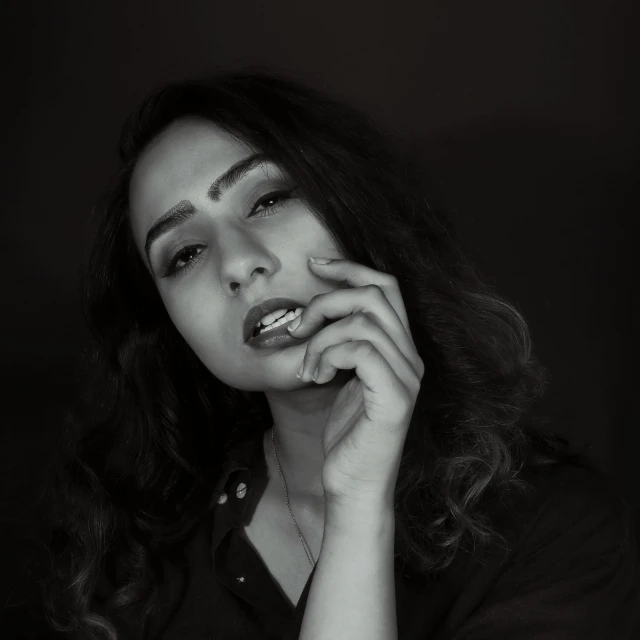 a black and white photo of a woman smoking a cigarette, inspired by irakli nadar, pexels contest winner, ☁🌪🌙👩🏾, young middle eastern woman, dark. studio lighting, instagram post