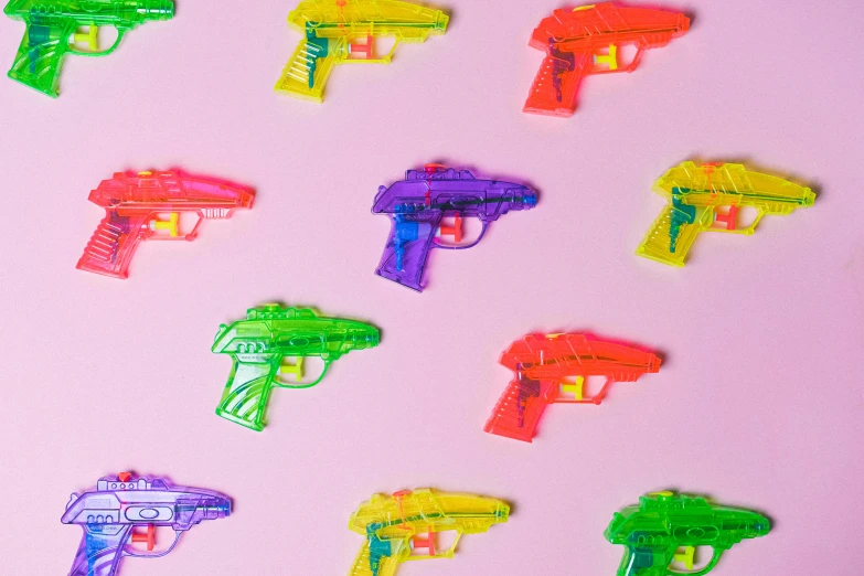 a bunch of plastic toy guns on a pink surface, inspired by Andy Warhol, trending on pexels, pop art, translucent neon skin, pop art patterns, neon rain, on a pale background