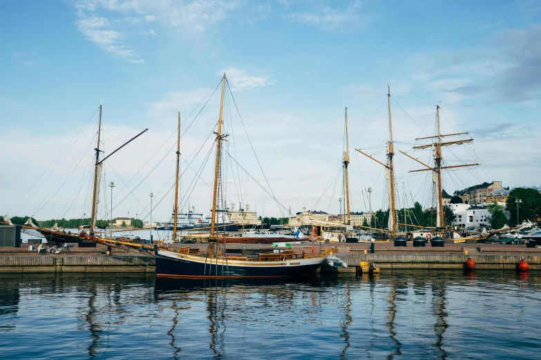 a boat that is sitting in the water, pexels contest winner, three masts, capital of estonia, shipping docks, wes anderson background