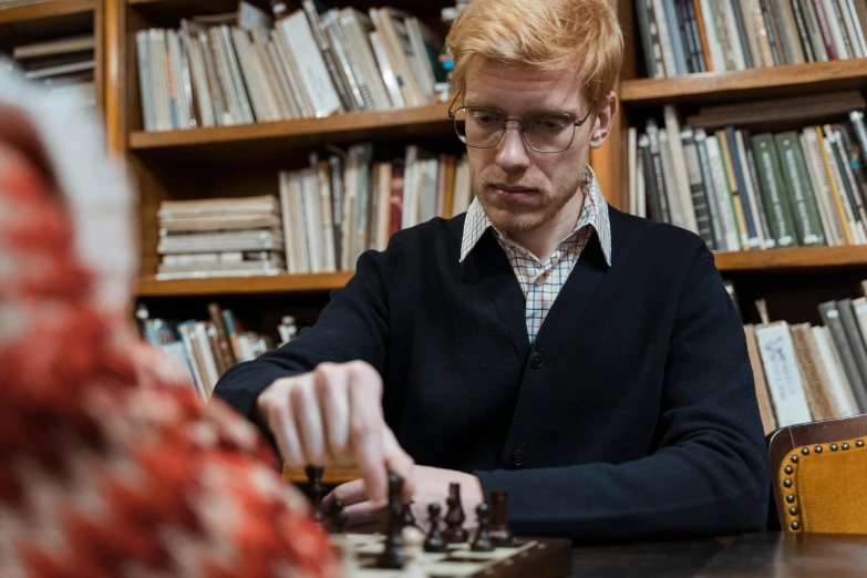 a man sitting at a table playing a game of chess, an album cover, inspired by Simon Marmion, academic art, looks like domhnall gleeson, librarian, anna nikonova, photograph taken in 2 0 2 0