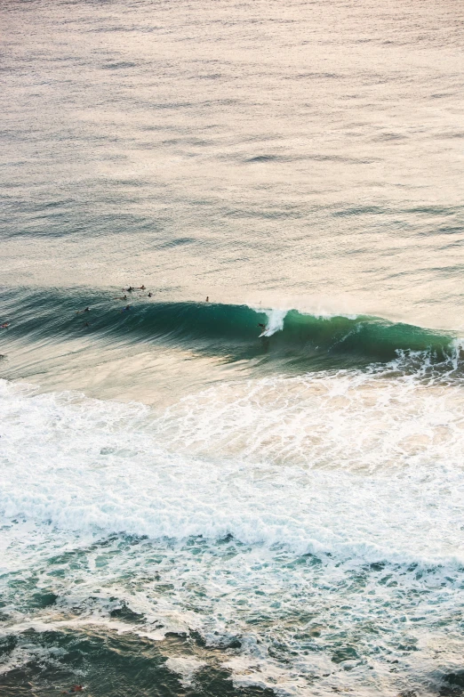 a man riding a wave on top of a surfboard, pexels contest winner, distant shot birds eye view, south african coast, slightly pixelated, a green